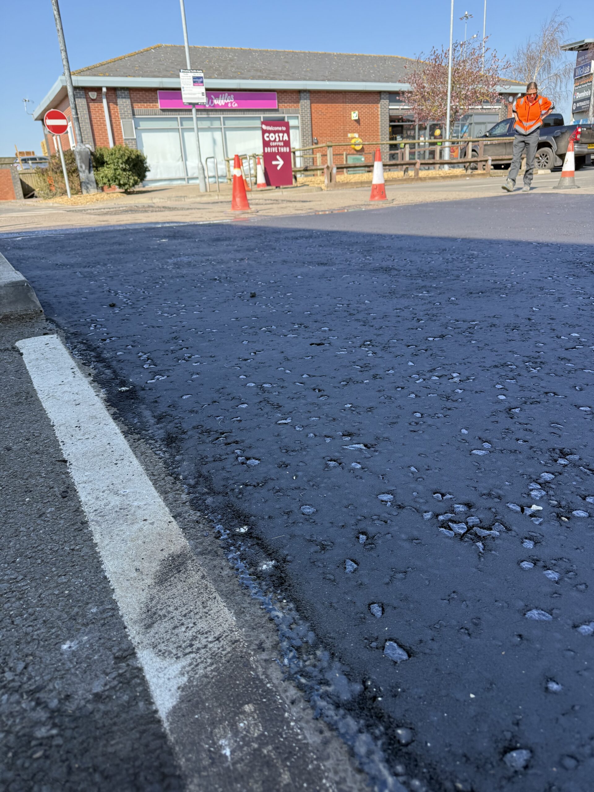 Wirtgen cold planer milling existing tarmac surface course on a retail park car park, showing the milled texture ready for new asphalt overlay